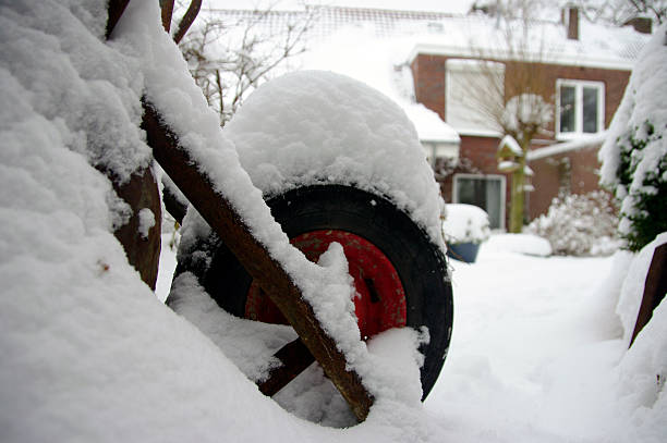 Wheelbarrow in wintergarden with a lot of snow