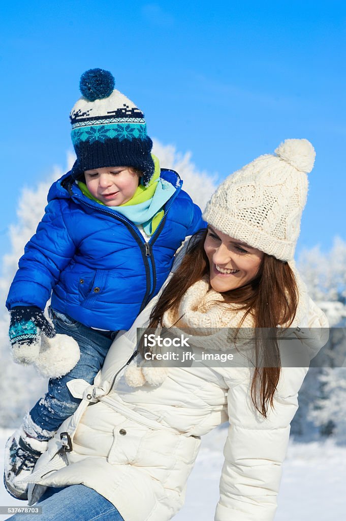 Portrait of baby boy and mother in winter day Lovely family having fun outdoor - snowy woodland 2015 Stock Photo