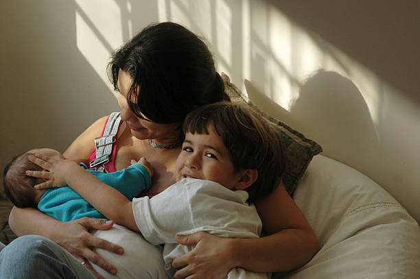 istock Baby sleeping on the young mother's lap with brother together. 537678733