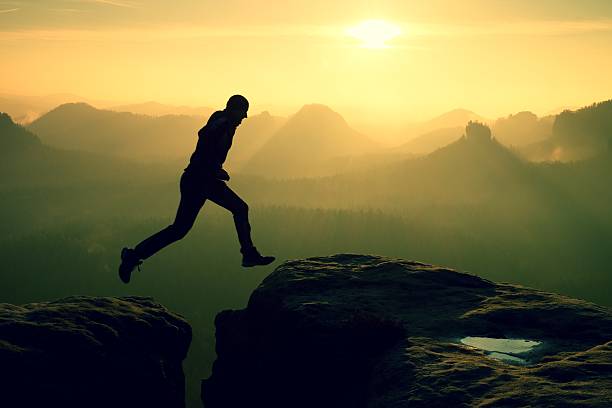 istock Crazy hiker jump between cliffs. Amazing mountains, heavy mist 537686146