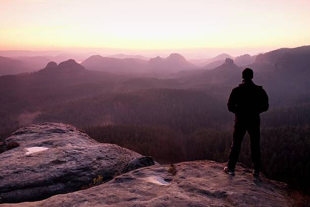 istock Man on sandstone rock watching to Sun. Beautiful spring morning. 537686668