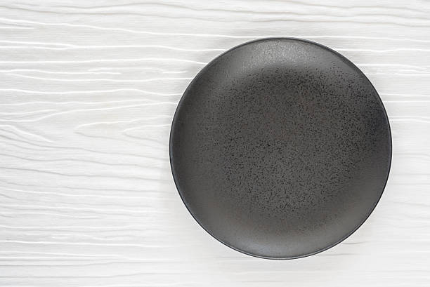 istock Black ceramic bowl on the white wooden table 537690466