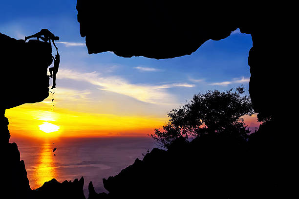 istock Man helping a friend who fell from a rock climbing. 537691376