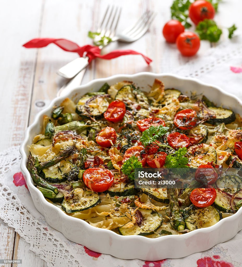 Vegetarian casserole with pasta, zucchini, cherry tomatoes, asparagus and onions Vegetarian dish with organic vegetables and pasta farfalle Asparagus Stock Photo