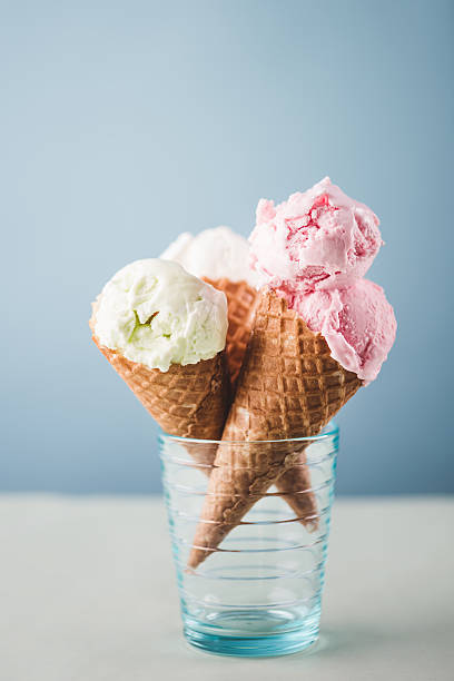 fragole e pera gelato coni su sfondo blu - strawberry ice cream flash foto e immagini stock