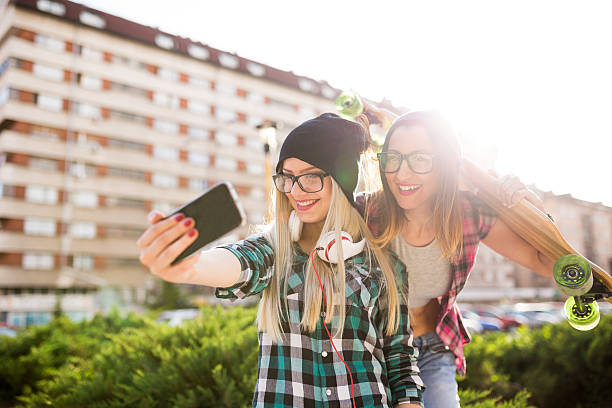istock Hipster girlfriends taking a selfie in urban city context 537697890