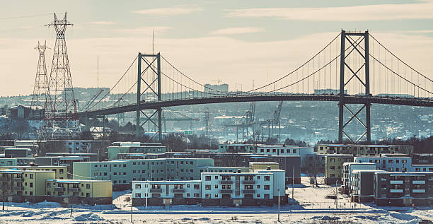 Abandoned Neighbourhood An abandoned apartment building complex in the foreground of the A. Murray McKay toll bridge on a cold February afternoon. Mild cross processing. run down neighborhood stock pictures, royalty-free photos & images