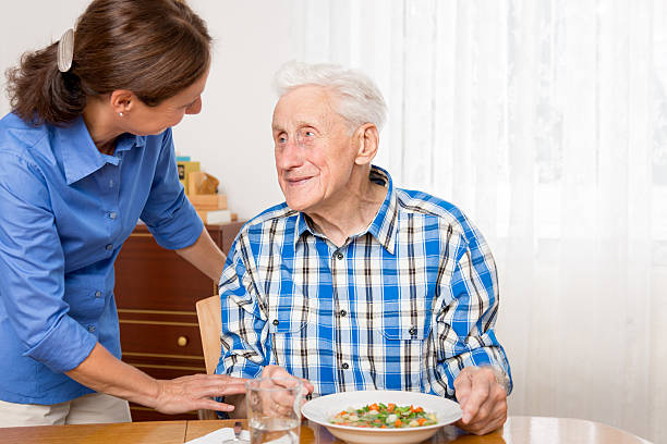 istock Caregiver helping senior man to eat 537698661