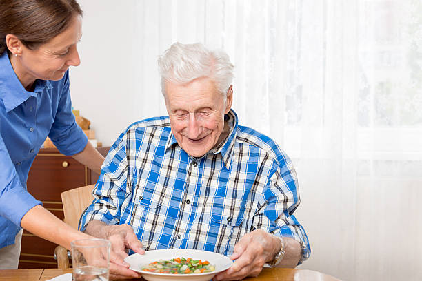 istock Home care nurse with senior patient having lunch 537698663