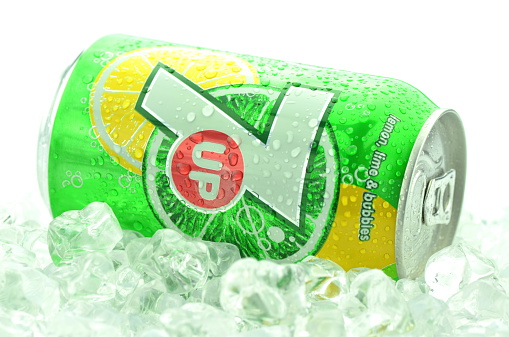 Kwidzyn, Poland - March 31, 2014: Can of 7 Up drink in ice isolated on white. 7 Up is lemon-lime flavored drink. 7 Up was created by Charles Leiper Grigg in 1929