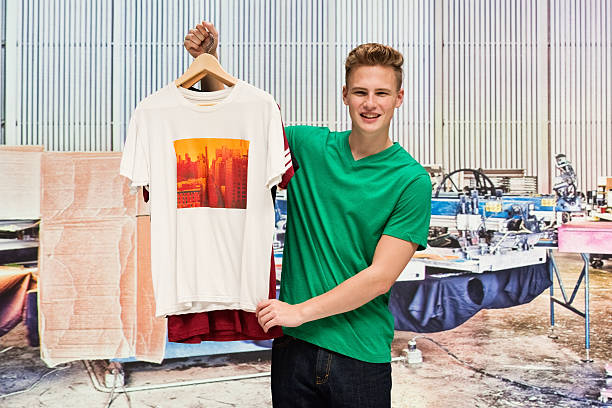 Smiling male holding t-shirthttp://www.twodozendesign.info/i/1.png