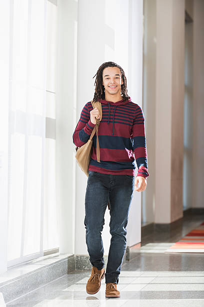 istock Male college student walking down hallway 537701077