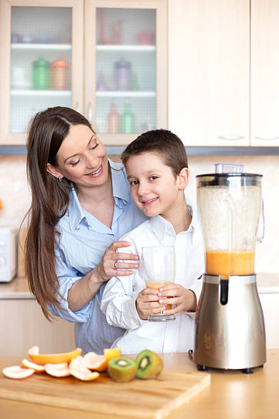 istock Mother and son making fresh orange juice 537701283