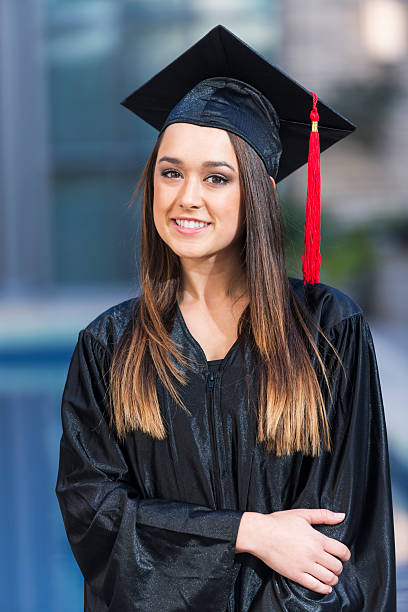 istock Young woman in graduation cap and gown 537703003