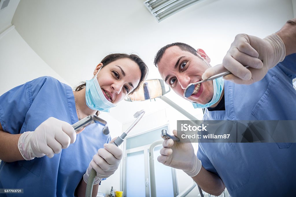 Dentists Holding Dental Tools Looking at Camera with Scary Faces Dentists Holding Dental Tools Looking at Camera with Scary Faces. Personal or Patient Point of View, POV. Dental Fear theme. Dentist Stock Photo