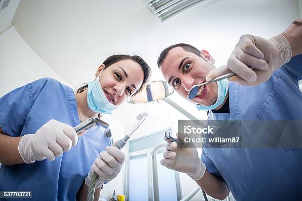 Dentists Holding Dental Tools Looking At Camera With Scary Faces Stock Photo - Download Image Now