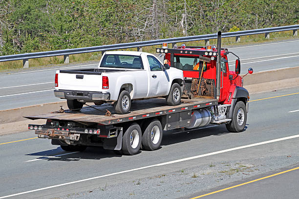 istock Tilt Bed Tow Truck Transporting An Old Model, Nondescript Vehicle 537706940