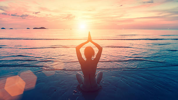 istock Silhouette young woman practicing yoga on the sunset beach. 537711334