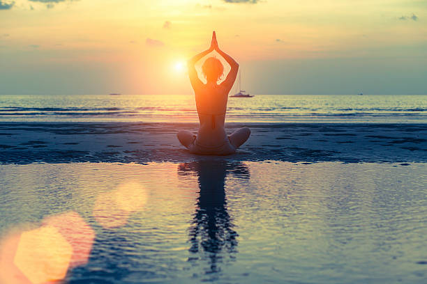 istock Silhouette woman practicing yoga at seashore during sunset. 537711412