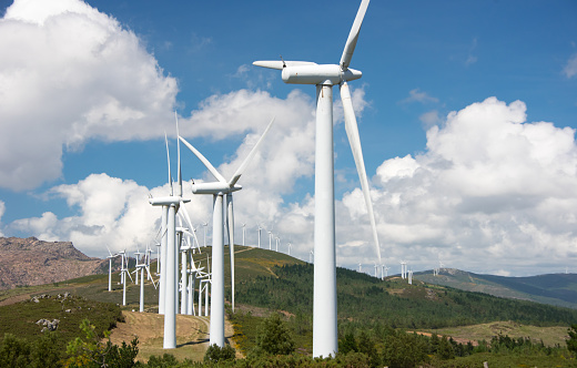 row of turbines of windmill powered plant on hills in Europe