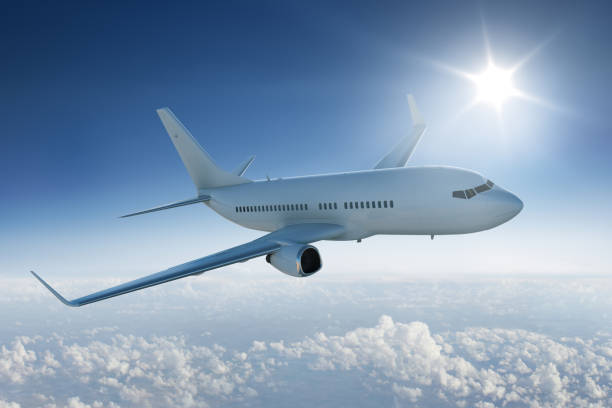 istock Airliner flying past the sun - in blue sky 537715171