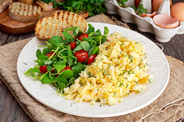 istock Scrambled eggs on plate with vegetables and grilled toast. 537717364