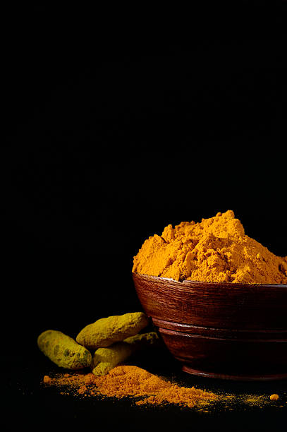 istock Turmeric powder with roots in wooden bowl 537718100