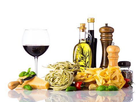 Italian or mediterranean cuisine food with Red Wine, parmigiano-reggiano parmesan cheese and tagliatelle pasta and cooking ingredients.