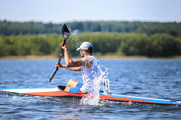 Chelyabinsk, Russia - May 28, 2016: athlete at rowing kayak on lake during competition. spray of water under  paddle during Ural championship in rowing