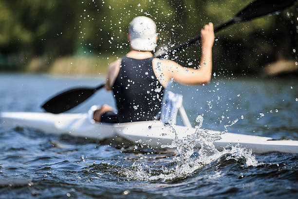 Chelyabinsk, Russia - May 28, 2016: athlete at rowing kayak on lake during competition.splashing water in foreground during Ural championship in rowing