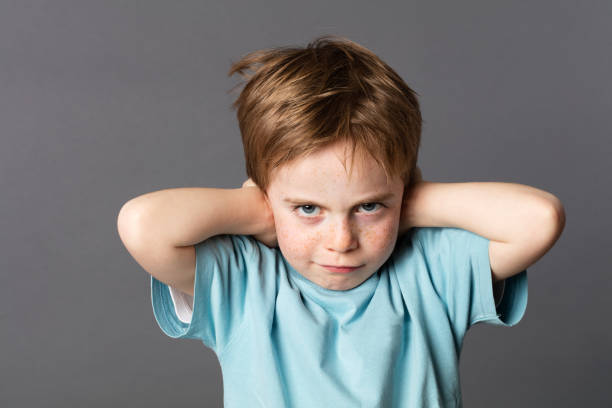 istock stubborn young kid teasing, covering closed ears, ignoring parents 537722764