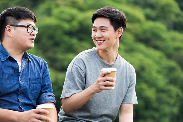 Two College friends having a coffee break at the park in Kyoto, Japan.