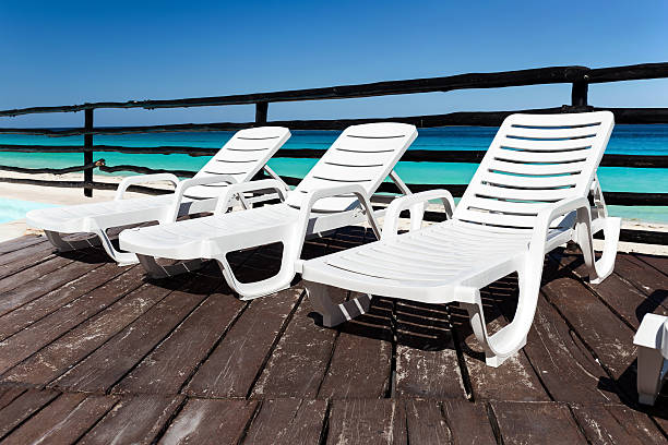istock Luxury sunbeds on wooden floor near swimming pool 537725310
