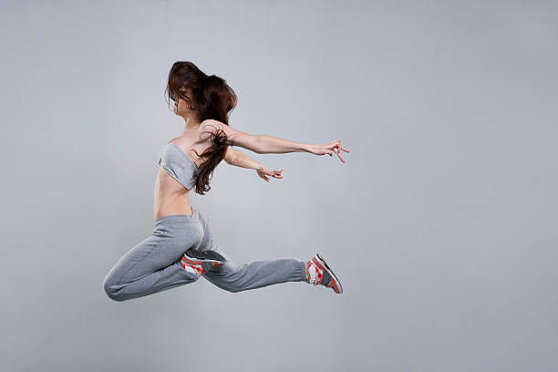 istock Beautiful young woman dancer jumping in studio 537727454