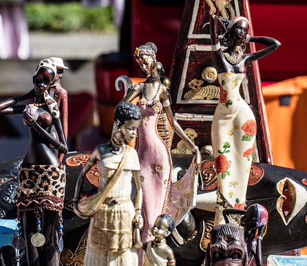 display of various African women figurines and ceramic black dolls for decoration or collection at garage sale of flea market, outdoors