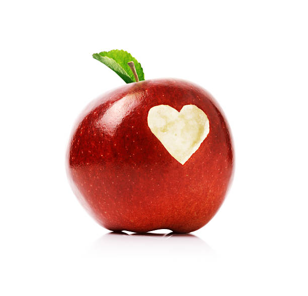 Red apple with heart symbol Red delicious apple with a love heart shape bitten into the flesh carving fruit stock pictures, royalty-free photos & images