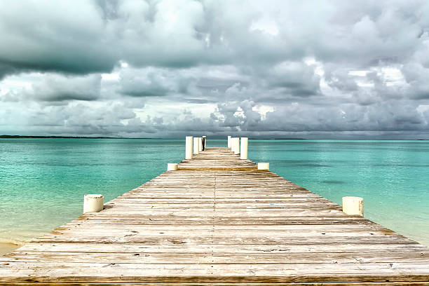 Empty pier by the sea surrounded by water.