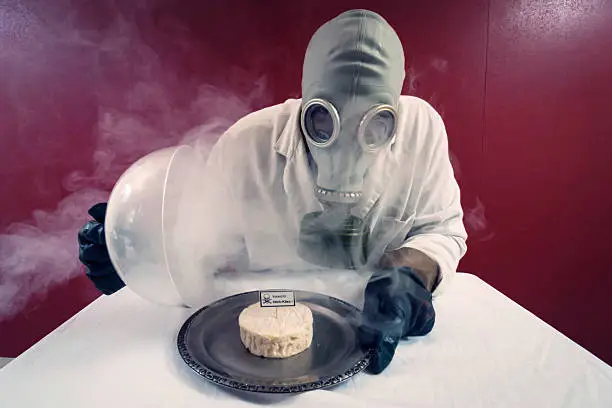 Man in front of a plate with cheese under cheese cover