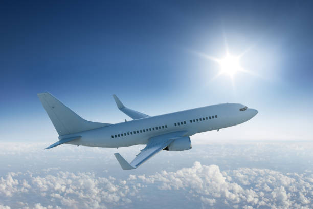 istock Airliner flying past the sun - in blue sky 537741795