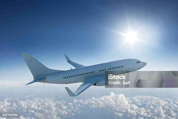 Airliner Flying Past The Sun In Blue Sky Stock Photo - Download Image Now - Side View, Airplane, Commercial Airplane