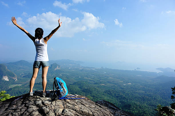 istock cheering hiking woman on mountain peak 537763507
