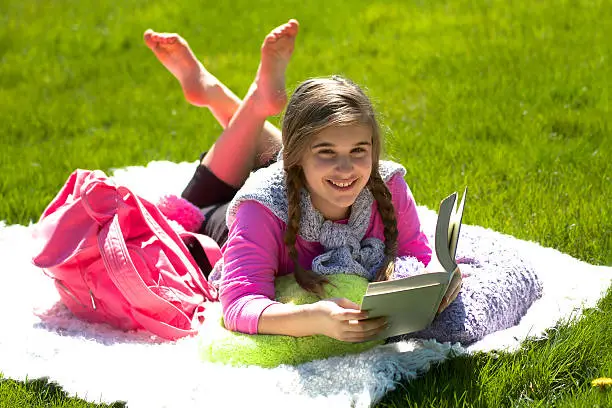 Photo of Girl smiling reading book