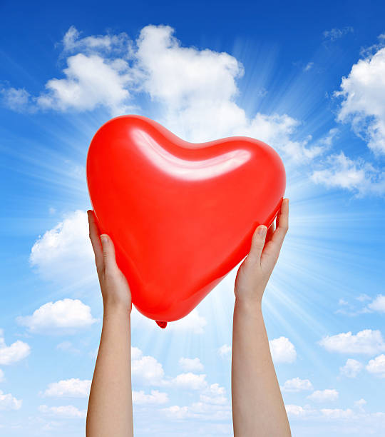 istock Balloon in the shape heart in hands 537792095