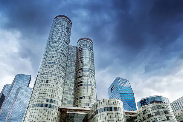 Dark clouds over modern buildings in the business district of La Defense, West of Paris, France.