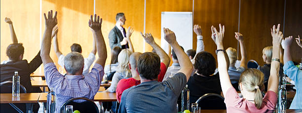 взрослые студенты, поднимая руки на семинар - seminar presentation asking business стоковые фото и изображения