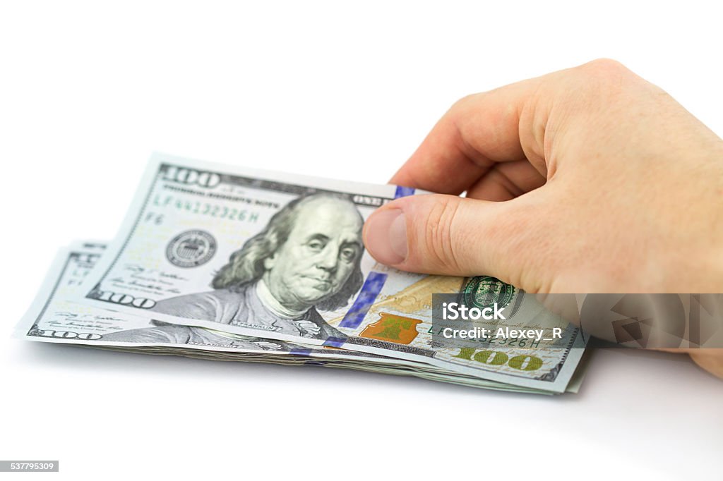 Hand putting one hundred dollars isolated on white background 2015 Stock Photo