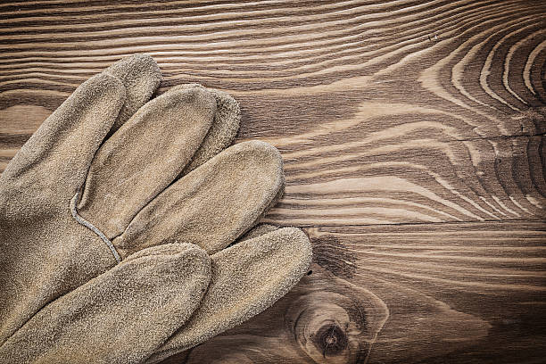 istock Pair of protective gloves on vintage wood board construction con 537803898