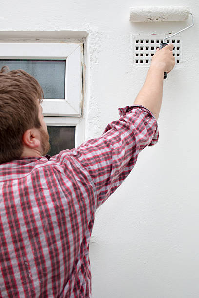 istock Man painting house wall, stepladder and roller. DIY Home Improvement. 537806040