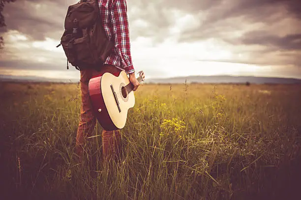 Photo of young man in nature with guitar
