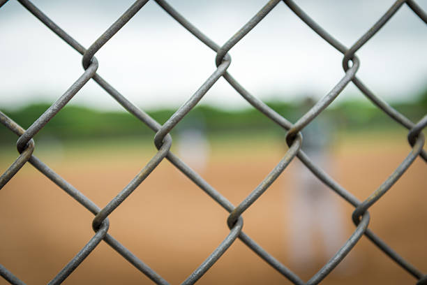 istock Baseball Fence with blurred player in background 537810800